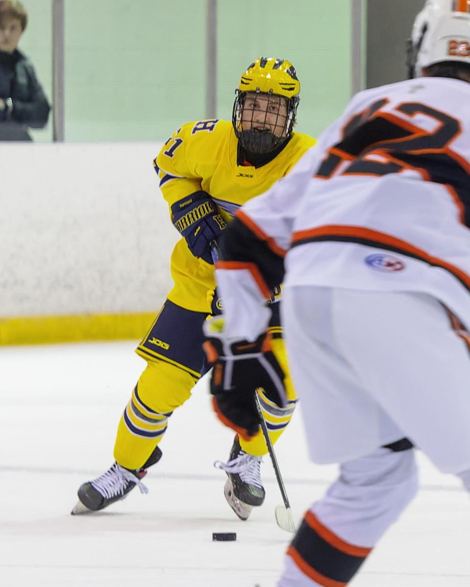 Hartland's Lucas Henry carries the puck while being defended by Birmingham Brother Rice's Caiden Ramos Saturday, Dec. 10, 2022 at Eddie Edgar Ice Arena.