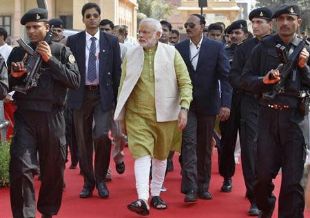 Narendra Modi (C), prime ministerial candidate for the Bharatiya Janata Party (BJP) and Gujarat's chief minister, is surrounded by his security personnel as he arrives to attend a public meeting at Somnath in Gujarat February 1, 2014. REUTERS/Amit Dave