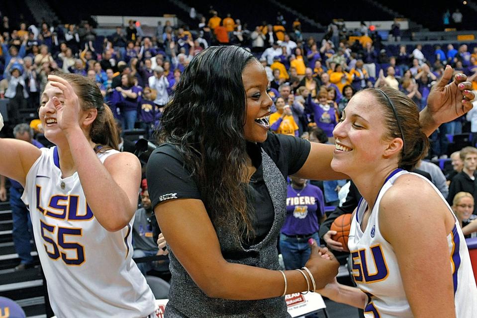 Tasha Butts (center), then an LSU assistant coach, celebrates a 2013 victory with guard Jeanne Kenney (right) as Theresa Plaisance (55) walks past.