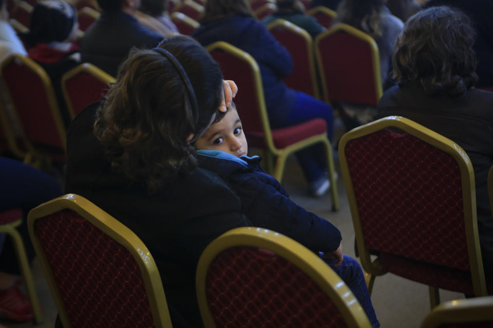 In this Jan. 20, 2019 photo, a little boy is caressed by his mother during Sunday service at Mart Shmony Orthodox Church the northern town of Irbil, Iraq. Two years after it was liberated from Islamic State militants, only a fraction of Christian residents have returned to Bartella. Many fear intimidation by the town’s population of Shabak, a Shiite Muslim ethnic group who dominate the militias that now run Bartella. Most now live in Ankawa, the Christian neighborhood of Irbil. (AP Photo/Fay Abuelgasim)