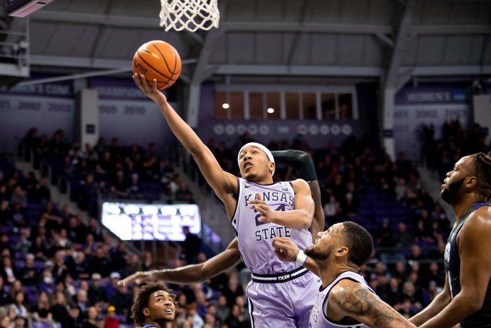 Kansas State guard Nijel Pack (24) leaps through TCU defenders to score during the first half of an NCAA college basketball game in Fort Worth, Texas, Saturday, Feb. 5, 2022. (AP Photo/Emil Lippe)