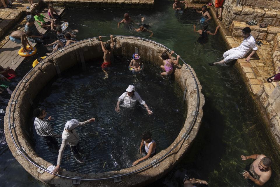 FILE - Israelis and Palestinians bathe in a cool natural spring in the Judean Desert, West Bank, Aug 1, 2023. UN weather agency says Earth sweltered through the hottest summer ever as record heat in August capped a brutal, deadly three months in northern hemisphere.(AP Photo/Ohad Zwigenberg, File)