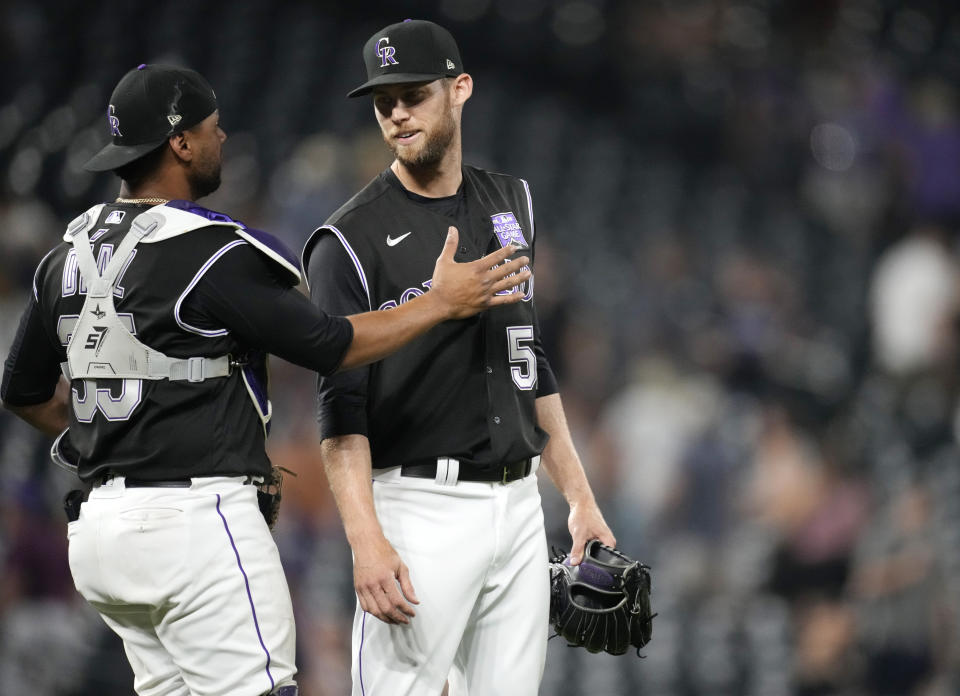 Colorado Rockies catcher Elias Diaz, left, congratulates relief pitcher Daniel Bard after the team's baseball game against the Milwaukee Brewers Thursday, June 17, 2021, in Denver. The Rockies won 7-3. (AP Photo/David Zalubowski)