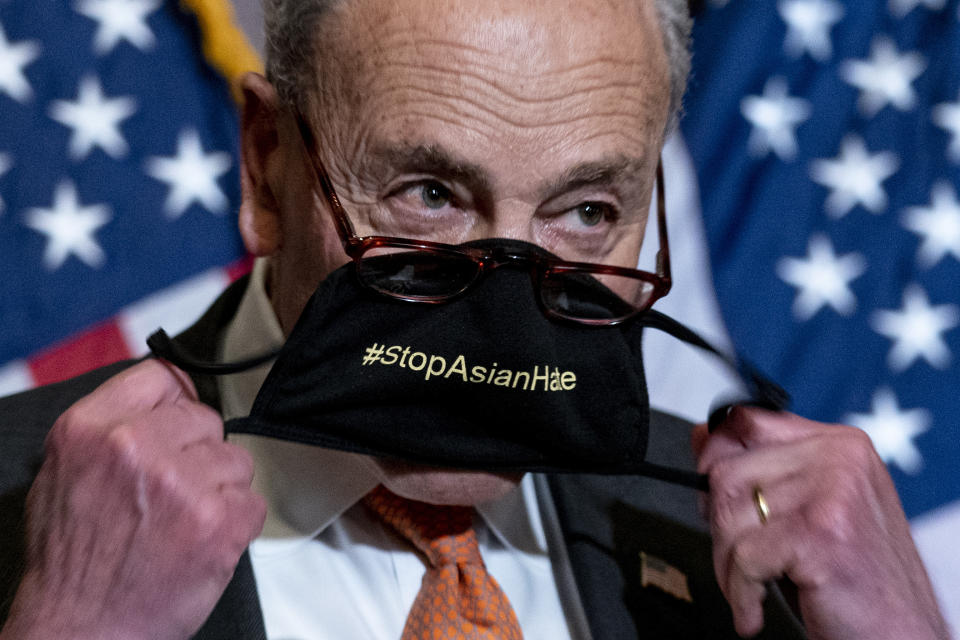 Senate Majority Leader Chuck Schumer of N.Y., takes off his mask that reads #StopAsianHate as he speaks at a news conference after the Senate passes a COVID-19 Hate Crimes Act on Capitol Hill, Thursday, April 22, 2021, in Washington. (AP Photo/Andrew Harnik)