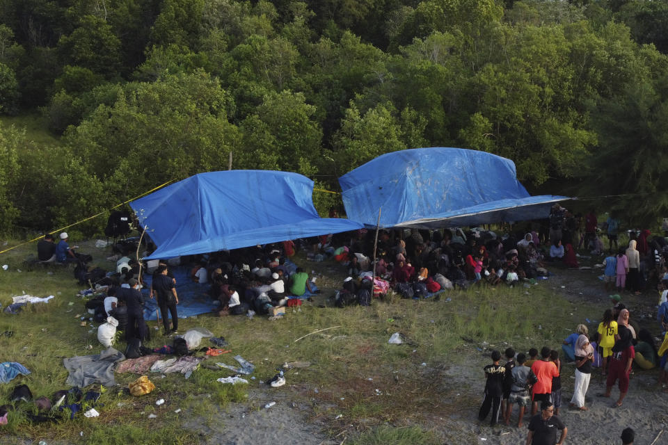 Ethnic Rohingya people take shelter under a a tent after landing on a beach in Kuala Besar, North Sumatra, Indonesia, Sunday, Dec. 31, 2023. Dozens of likely Rohingya refugees, mostly hungry and weak women and children, were found on a beach in Indonesia's North Sumatra province after weeks at sea, officials said on Sunday. (AP Photo/Dedy Zulkifli)