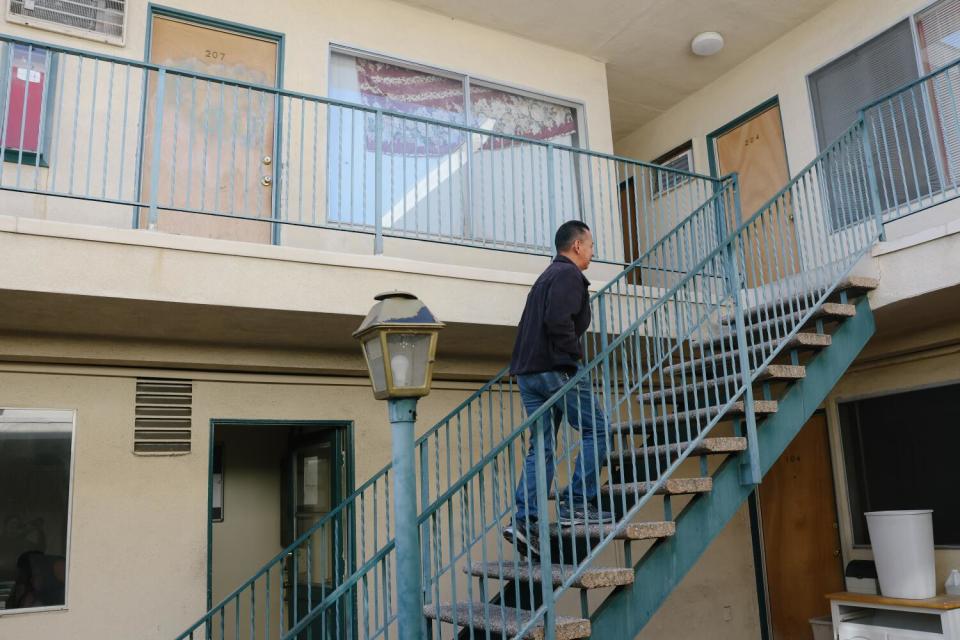 A man walking up an outdoor stairway at an apartment building