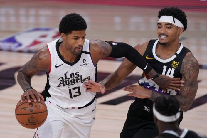 Los Angeles Clippers&#x27; Paul George (13) drives past Denver Nuggets&#x27; Gary Harris (14) during the first half of an NBA conference semifinal playoff basketball game Monday, Sept. 7, 2020, in Lake Buena Vista, Fla. (AP Photo/Mark J. Terrill)
