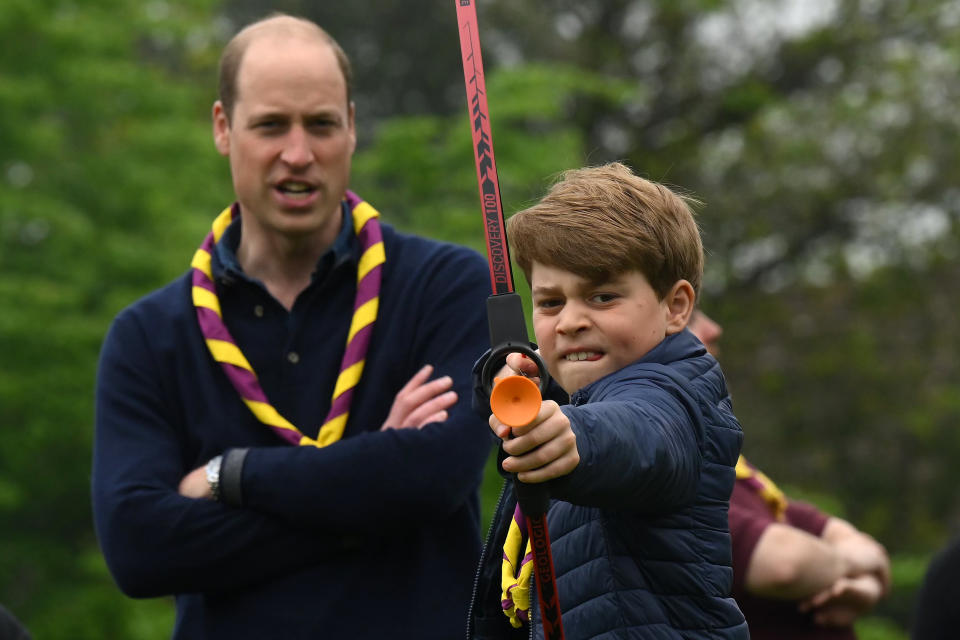 LONDON, ENGLAND - MAY 08: Watched by his father Prince William, Prince of Wales, Prince George of Wales tries his hand at archery while taking part in the Big Help Out, during a visit to the 3rd Upton Scouts Hut in Slough on May 8, 2023 in London, England. The Big Help Out is a day when people are encouraged to volunteer in their communities. It is part of the celebrations of the Coronation of Charles III and his wife, Camilla, as King and Queen of the United Kingdom of Great Britain and Northern Ireland, and the other Commonwealth realms that took place at Westminster Abbey on Saturday, May 6, 2023. (Photo by Daniel Leal - WPA Pool/Getty Images)