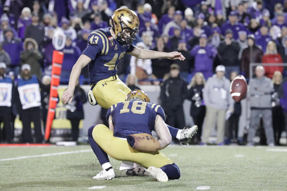 Navy kicker Bijan Nichols (43) kicks the winning 23-yard field goal as J.R. Osborn (18) holds in the final seconds of the fourth quarter in the Liberty Bowl NCAA college football game against Kansas State Tuesday, Dec. 31, 2019, in Memphis, Tenn. Navy won 20-17. (AP Photo/Mark Humphrey)