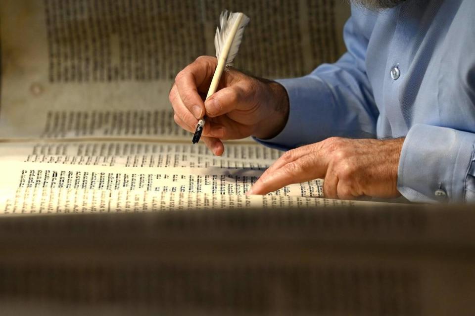 Rabbi Moshe Druin repairs a Torah scroll at Temple Beth El in Charlotte, NC on Tuesday, April 18, 2023. Tuesday is Holocaust Remembrance Day (Yom HaShoah). Druin, a sofer was repairing a Czech Memorial Scroll that survived the Holocaust. The Torah is around 300 years old.