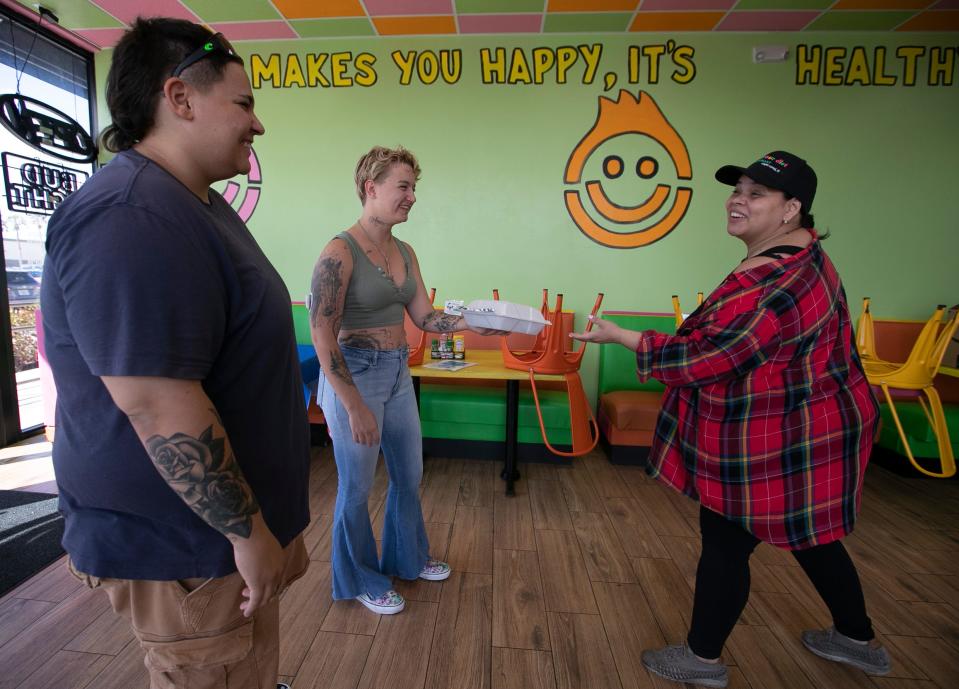 Ariana Hernandez, left, and Jordyn Post receive a meal package from Melissa Muniz at FK Your Diet in Cape Coral.