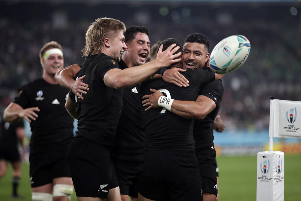 New Zealand's Aaron Smith (9) celebrates with teammates after scoring a try during the Rugby World Cup quarterfinal match at Tokyo Stadium between New Zealand and Ireland in Tokyo, Japan, Saturday, Oct. 19, 2019. (AP Photo/Mark Baker)