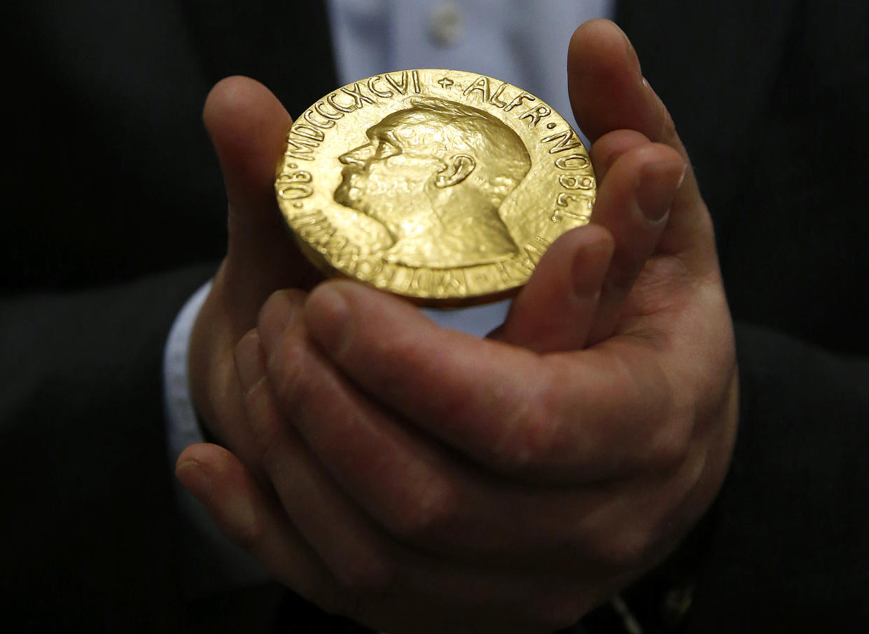 FILE - In this Thursday, March 27, 2014 file photo bidder Ole Bjorn Fausa, of Norway, holds the 1936 Nobel Peace Prize medal in Baltimore. The Nobel Peace Prize will be awarded on Friday Oct. 8, 2021. (AP Photo/Patrick Semansky, File)