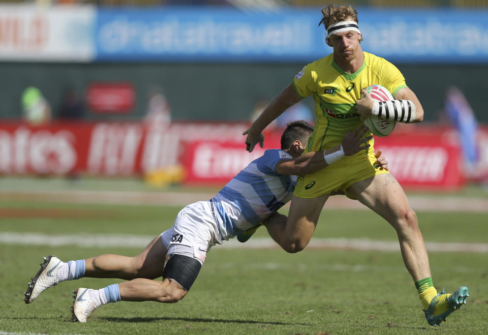 Australia's Ben O'Donnell, right, is tackled by Argentina's player in a quarterfinal match of the Emirates Airline Rugby Sevens in Dubai, the United Arab Emirates, Saturday, Dec. 1, 2018. (AP Photo/Kamran Jebreili)