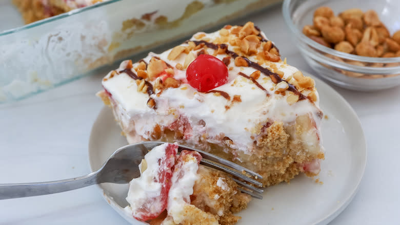 sliced banana split cake being cut into with a fork