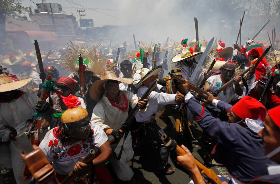 FILE – In this May 5, 2010 file photo, people dressed in period costumes re-enact the Battle of Puebla during “Cinco de Mayo” celebrations in Mexico City. The 150th anniversary of the Battle of Puebla, in which the U.S. helped Mexico combat the French occupation, is being used as an anchor to get U.S. tourists to visit the 16th-century colonial Mexican city. (AP Photo/Eduardo Verdugo, File)