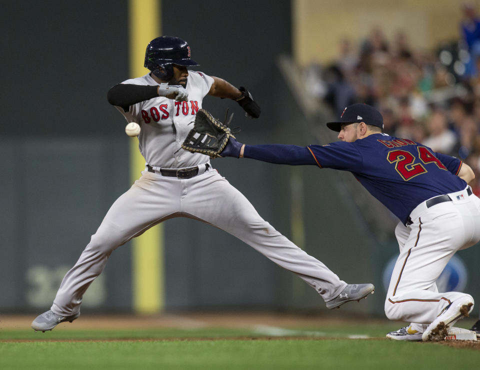 Minnesota Twins first baseman C.J. Cron, right, catches the ball as Boston Red Sox's Jackie Bradley Jr. jumps safely back to first in the eighth inning of a baseball game Monday, June 17, 2019, in Minneapolis. (AP Photo/Andy Clayton- King)