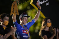 Stage winner Belgium's Jasper Philipsen celebrates on the podium after the twenty-first stage of the Tour de France cycling race over 116 kilometers (72 miles) with start in Paris la Defense Arena and finish on the Champs Elysees in Paris, France, Sunday, July 24, 2022. (AP Photo/Daniel Cole)