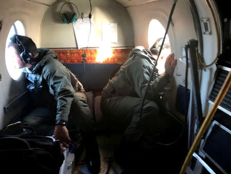 Members of the Argentine Navy look down at the sea from an airplane during a flight to search for the ARA San Juan submarine missing at sea, Argentina November 22, 2017. Argentine Navy/Handout via REUTERS