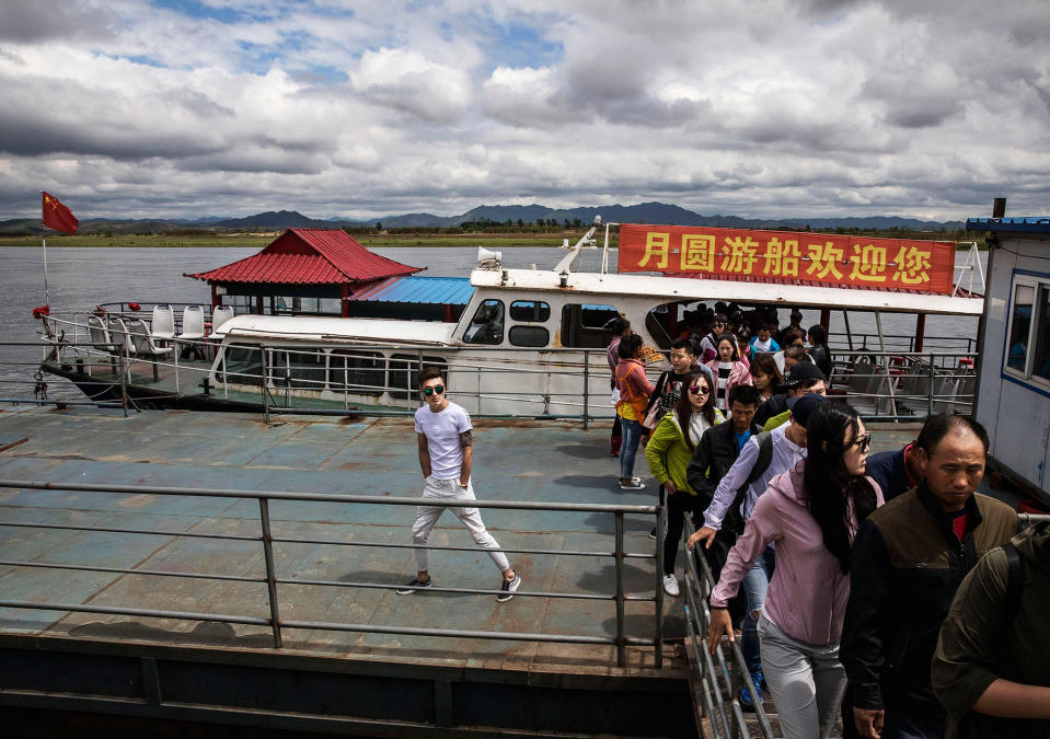 Chinese tourists disembark from a boat