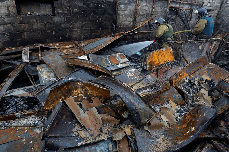 Los bomberos trabajan en un mercado local afectado por bombardeos durante el conflicto entre Rusia y Ucrania en Donetsk, Ucrania controlada por Rusia