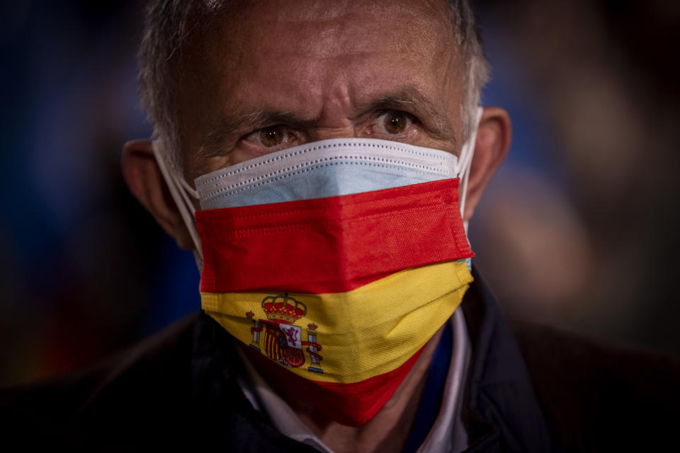 A supporter of conservative Madrid president Isabel Diaz Ayuso waits outside the popular party headquarters in Madrid, Spain, Tuesday, May 4, 2021. Madrid residents voted in droves for a new regional assembly in an election that tests the depths of resistance to virus lockdown measures and the divide between left-wing and right-wing parties. Regional President Isabel Díaz Ayuso, who called the early election by dissolving her center-right coalition, had set off to broaden her power base and open up to an alliance with the far-right. (AP Photo/Bernat Armangue)