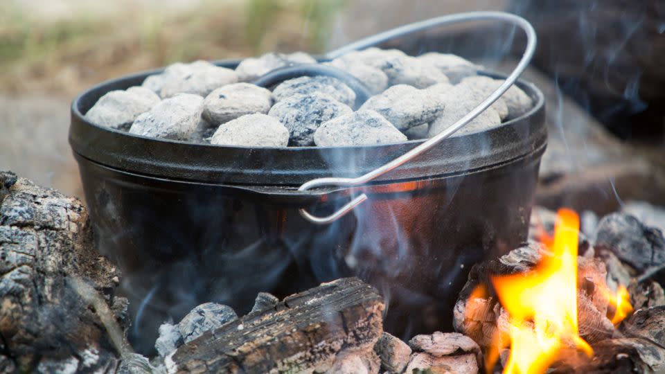A cast-iron Dutch oven is a versatile piece of outdoor cookware, allowing you to make slow-simmered stews or baked casserole dishes. - EntropyWorkshop/iStockphoto/Getty Images