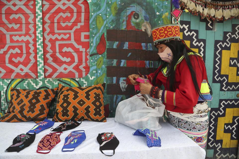 Indigenous Shipibo-Conibo displays for sale her artisanal goods including embroidered protective face masks, in the Cantagallo neighborhood of Lima, Peru, Thursday, Sept. 24, 2020. Today the South American nation has the highest per capita COVID-19 mortality rate of any country across the globe, according to John Hopkins University – and physicians there believe the country’s faulty testing approach is one reason why. (AP Photo/Martin Mejia)