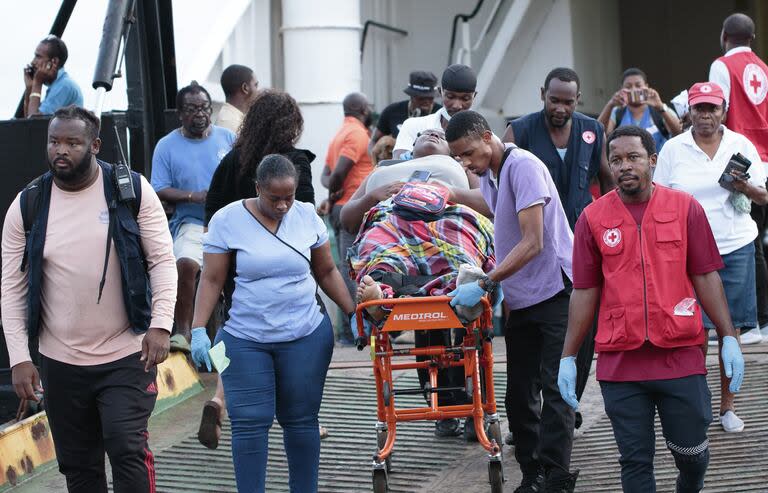 Miembros de la Cruz Roja transportan en camilla a una evacuada de Union Island cuando llega a Kingstown, San Vicente y las Granadinas