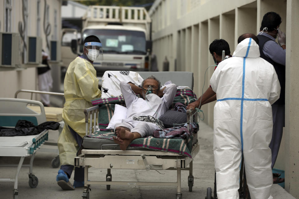 Afghan doctors wheel a patient breathing through an oxygen mask at the Afghan-Japan Communicable Disease Hospital to a special ward for COVID-19 patients, in Kabul, Afghanistan, Tuesday June 30, 2020. (AP Photo/Rahmat Gul)