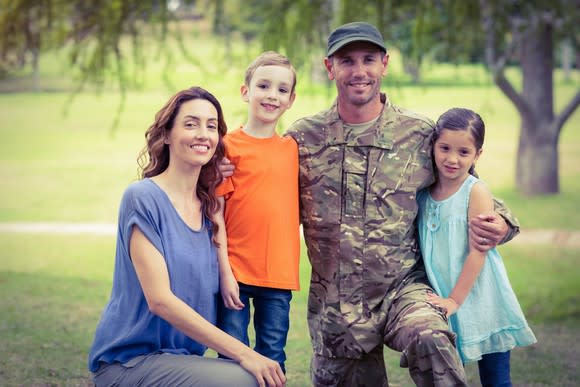 Man dressed in military uniform with woman and two children