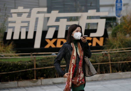 A woman walks past New Oriental Education & Technology Group headquarters in Beijing, China, November 16, 2016. REUTERS/Jason Lee