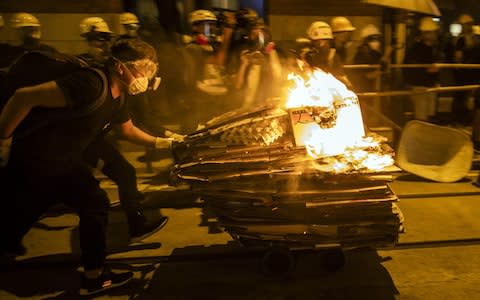 Demonstrators push a cart with cardboard boxes set on fire towards riot police  - Credit: Bloomberg