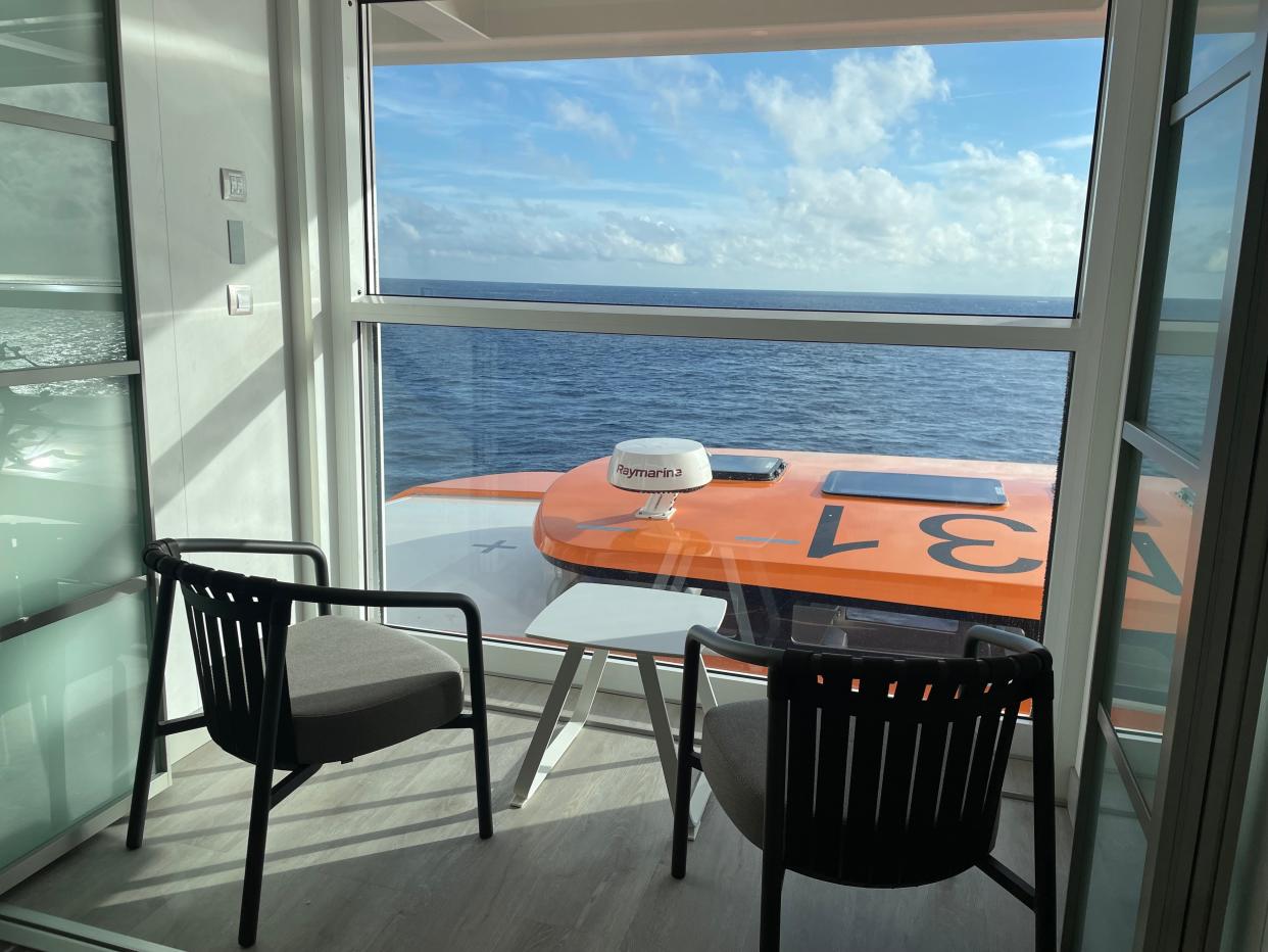 The stateroom's Infinite Veranda offers access to the ocean air via a retractable window.