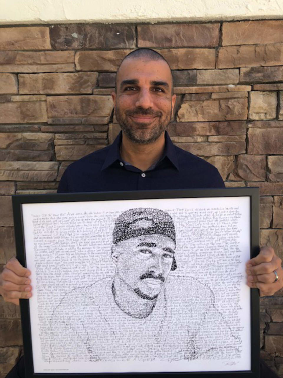 Scholar Barbod Salimi holding artwork of Tupac Shakur by artist Dan Duffy. (Courtesy Barbod Salimi)