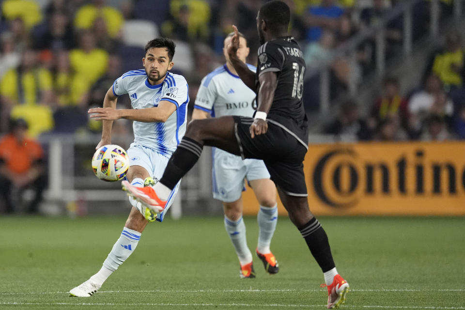 CF Montréal midfielder Mathieu Choinière, left, kicks the ball past Nashville SC midfielder Dru Yearwood (16) during the first half of an MLS playoff soccer match Saturday, May 4, 2024, in Nashville, Tenn. (AP Photo/George Walker IV)