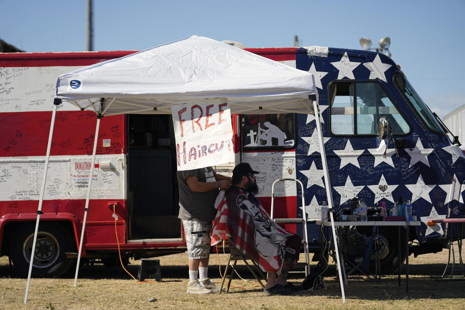 Irvin Russell Pelton Jr., left, gives free haircuts during a "Take Our Border Back" convoy and rally, Saturday, Feb. 3, 2024, in Quemado, Texas. (AP Photo/Eric Gay)