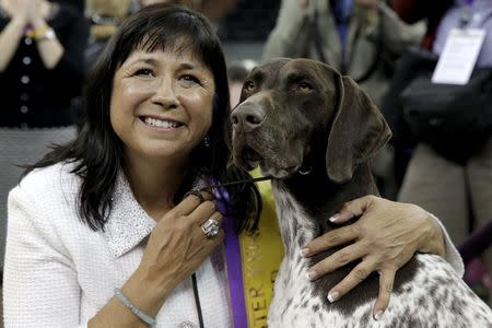Handler Valerie Nunez Atkinson poses with CJ, a German Shorthaired Pointer from the Sporting Group, after they won Best in Show at the Westminster Kennel Club Dog show at Madison Square Garden in New York February 16, 2016. REUTERS/Brendan McDermid