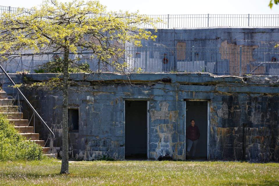 A woman takes a look at the WWII era bunker built into a hill at Fort Taber Park in the south end of New Bedford.