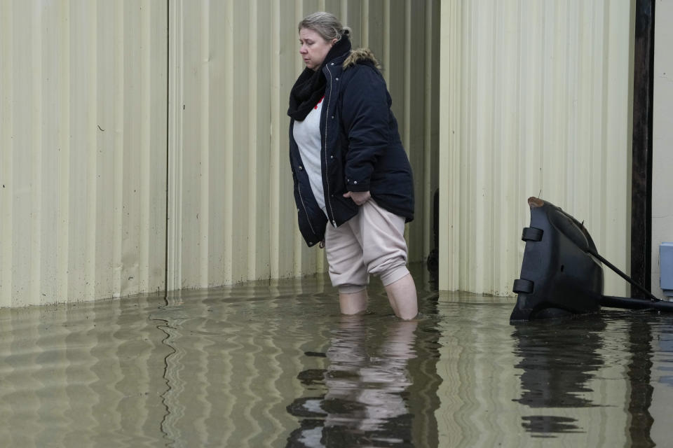 A woman walks through her flooded front yard in her home at Windsor on the outskirts of Sydney, Australia, Tuesday, July 5, 2022. Hundreds of homes have been inundated in and around Australia’s largest city in a flood emergency that was threatening 50,000 people, officials said on Tuesday. (AP Photo/Mark Baker)