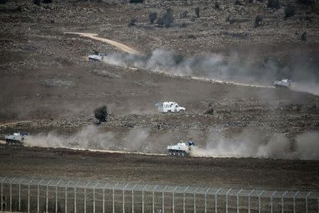 U.N. vehicles drive in Syria, near the border fence with the Israeli-occupied Golan Heights August 31, 2014. REUTERS/Baz Ratner