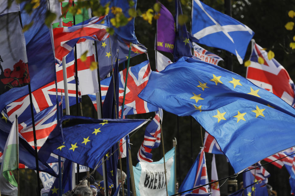 Flags fly outside Parliament in London, Wednesday, Oct. 30, 2019. Britons will be heading out to vote in the dark days of December after the House of Commons on Tuesday backed an early national vote that could break the country's political impasse over Brexit — or turn out to be merely a temporary distraction. (AP Photo/Kirsty Wigglesworth)