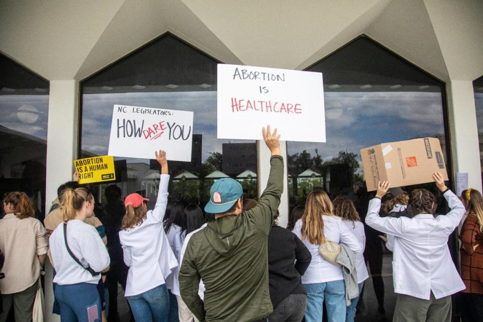 Demonstrators hold signs outside the legislature auditorium where a House Rules meeting was underway, May 3, 2023 at the Legislative Building. Republican state lawmakers announced their plan to limit abortion rights across the state. Travis Long/tlong@newsobserver.com