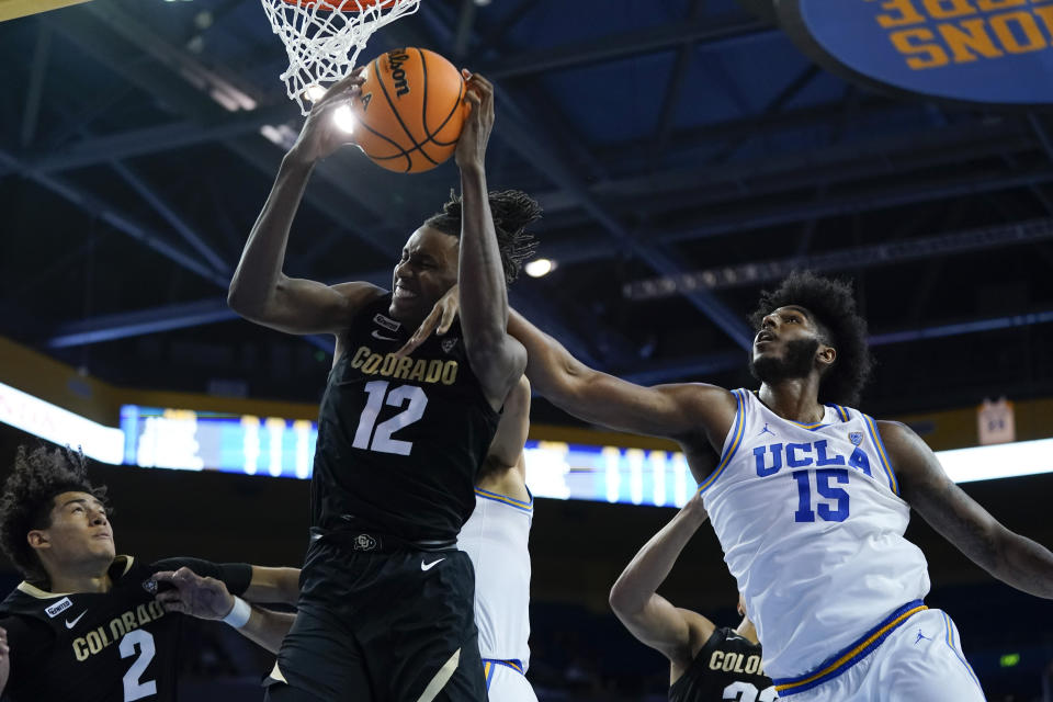 Colorado forward Jabari Walker (12) and UCLA center Myles Johnson (15) reach for a rebound during the second half of an NCAA college basketball game in Los Angeles, Wednesday, Dec. 1, 2021. (AP Photo/Ashley Landis)