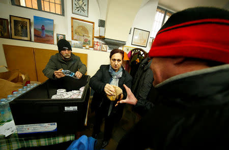 Volunteers distribute cheeseburgers donated by McDonald's to a charity organization which bestowed them to needy people at a walk-in clinic in Rome, Italy January 16, 2017. REUTERS/Tony Gentile