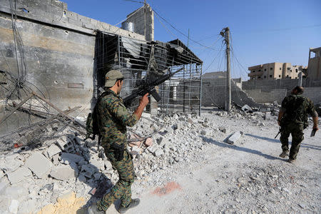 Members of the Syrian Democratic Forces walk at their position, during the fighting with Islamic State's fighters in Nazlat Shahada, a district of Raqqa, Syria August 16, 2017. REUTERS/Zohra Bensemra