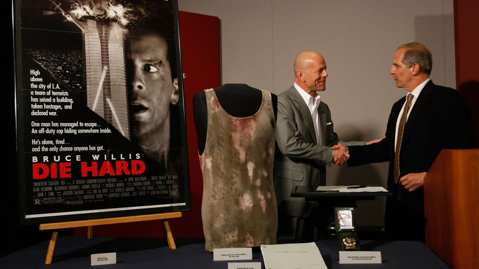 Bruce Willis presenting the National Museum of American History with props from the "Die Hard" series in 2007, including a tank top from the first film.  - Win McNamee/Getty Images