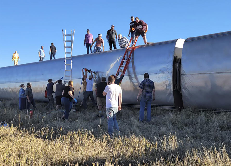 In this photo provided by Kimberly Fossen people work at the scene of an Amtrak train derailment on Saturday, Sept. 25, 2021, in north-central Montana. Multiple people were injured when the train that runs between Seattle and Chicago derailed Saturday, the train agency said. (Kimberly Fossen via AP)