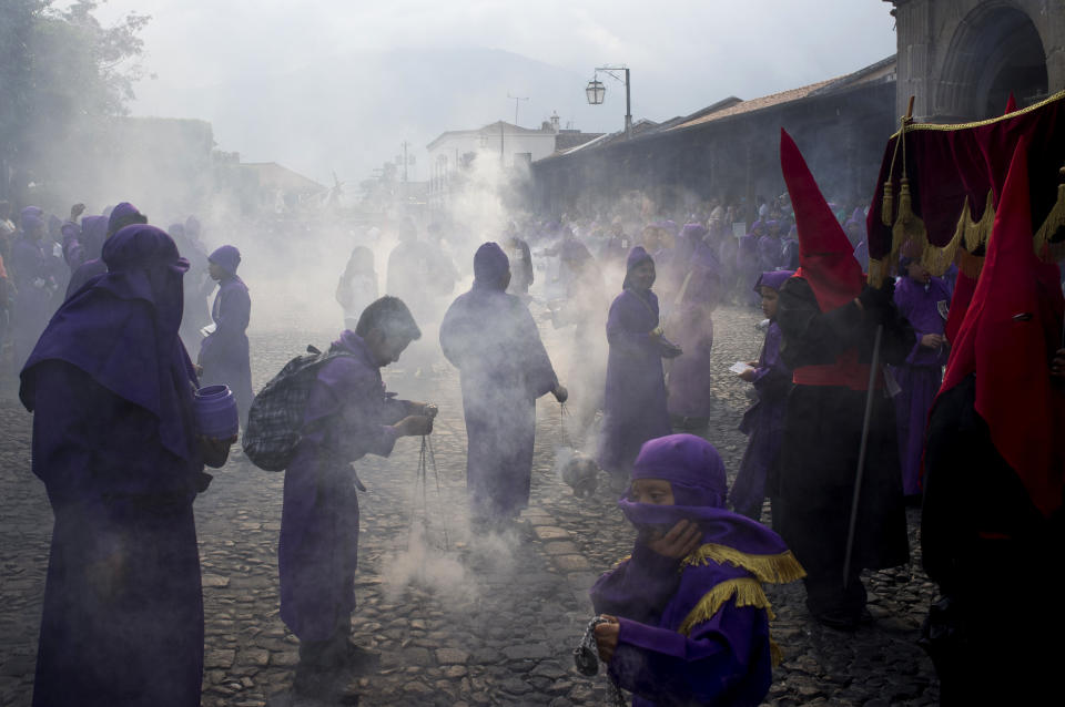 Penitents burn incense during a procession by Saint Francis church as part of Holy Week celebrations in Antigua Guatemala, Thursday, April 17, 2014. (AP Photo/Moises Castillo)