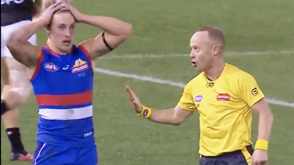 AFL umpire 'Razor' Ray Chamberlain is seen paying a free kick against Western Bulldogs player Roarke Smith.